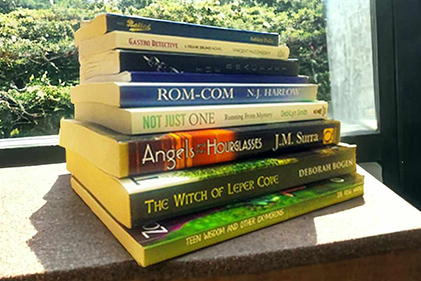 Decorative photo of a stack of printed books formatted by Erika Q. Stokes